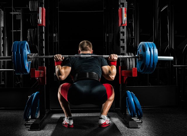 man doing barbell back squats