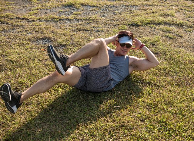 man doing bicycle crunches outdoors