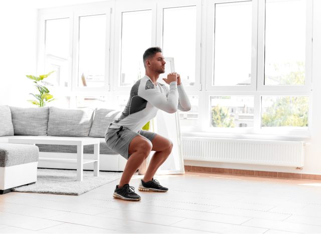 man doing bodyweight squats at home