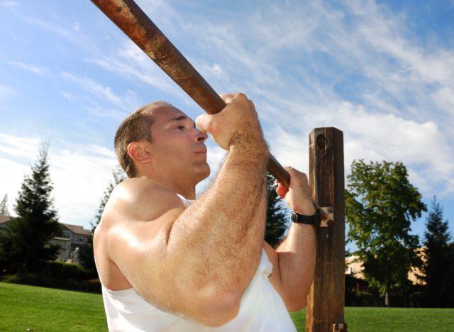 man doing chin-ups outdoors