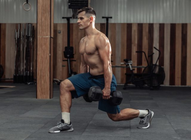 man doing dumbbell exercises, reverse lunges at the gym