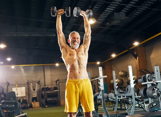 fit man doing dumbbell overhead press