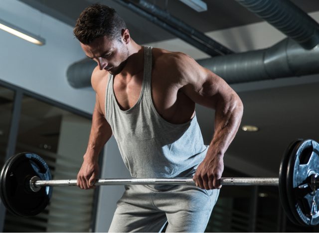 fitness man doing barbell row at the gym