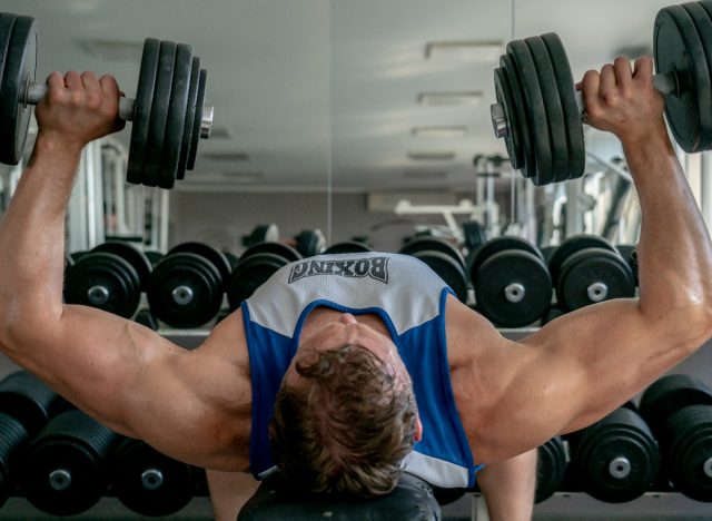 fit man doing bench presses strength exercises