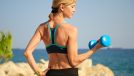 fit woman holding dumbbell outdoors, concept of exercises to change your body shape after 40