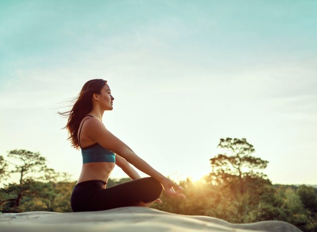 fit woman meditating on sunny morning, concept of how to stay fit without exercising