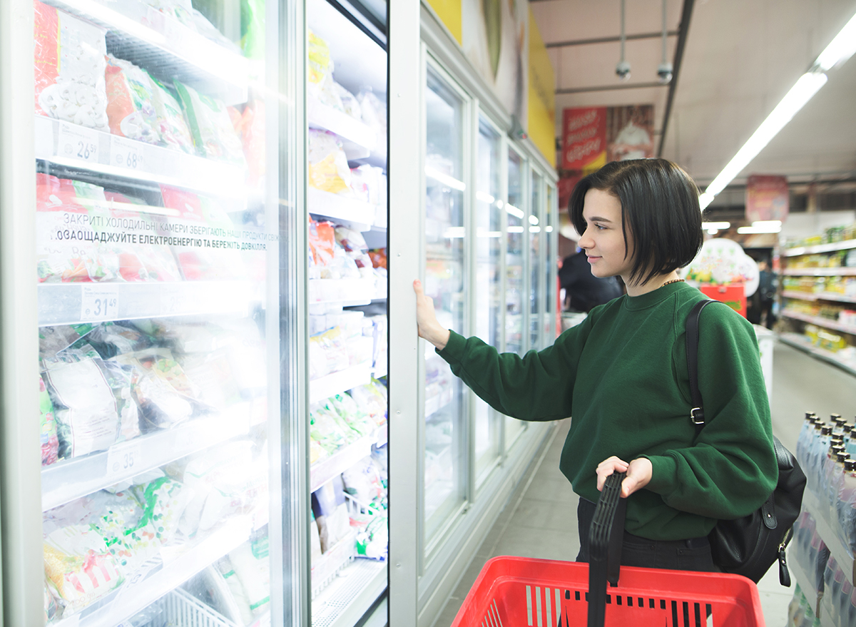 The buyer near the freezer in the supermarket