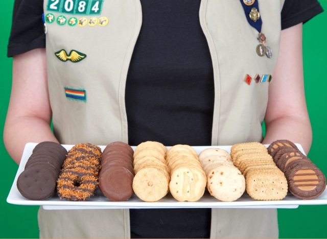 girl scout holding plate of girl scout cookies