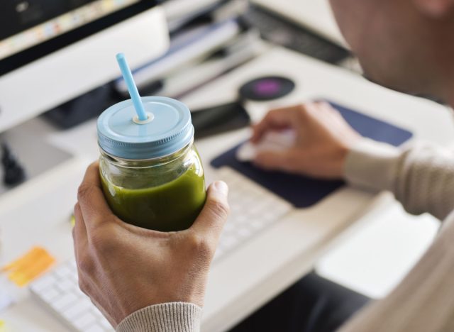 green smoothie man drinking at desk