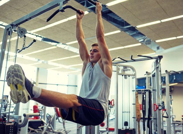 man demonstrating hanging leg raise to get rid of hanging belly fat