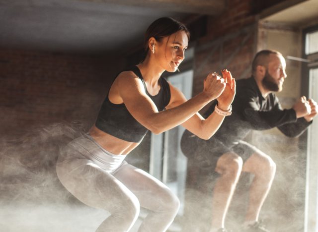 fitness duo performing jump squats at the gym