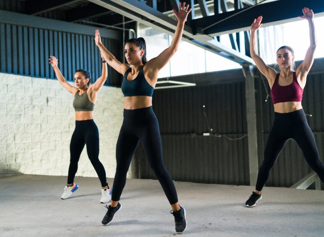 women doing jumping jacks in fitness class