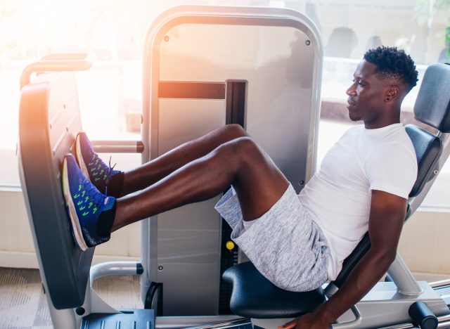 man using a leg press machine at the gym performing a leg workout to build muscle