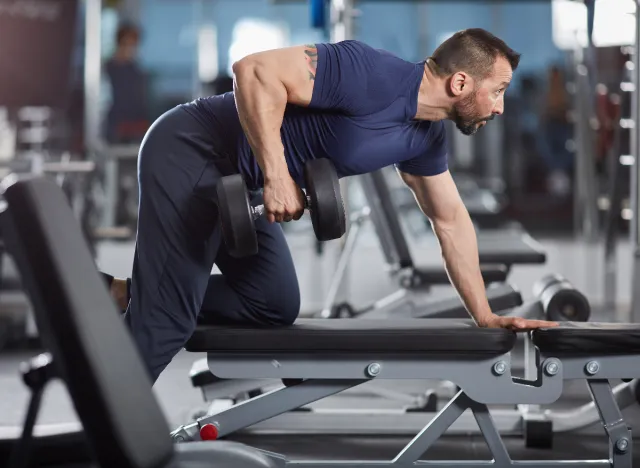 man doing dumbbell rows as part of hypertrophy workout to build size and strength