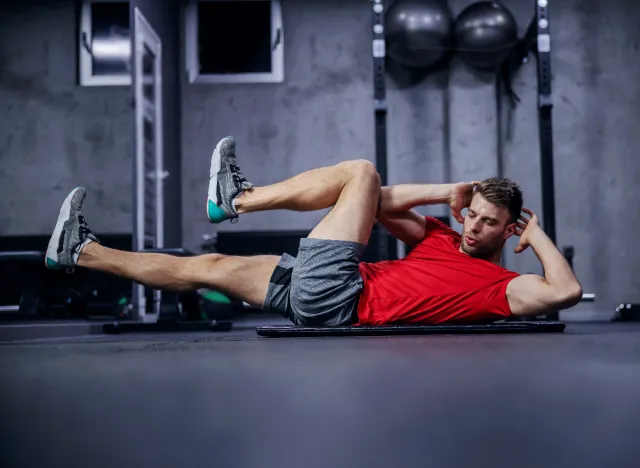 man doing bicycle crunches at the gym as part of a strength and conditioning workout
