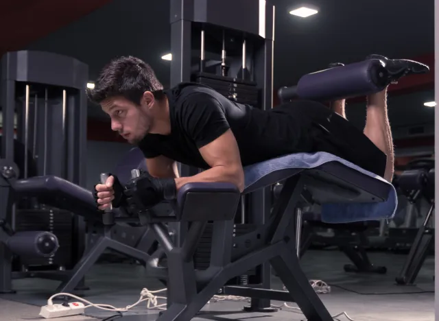 man doing machine lying leg curls