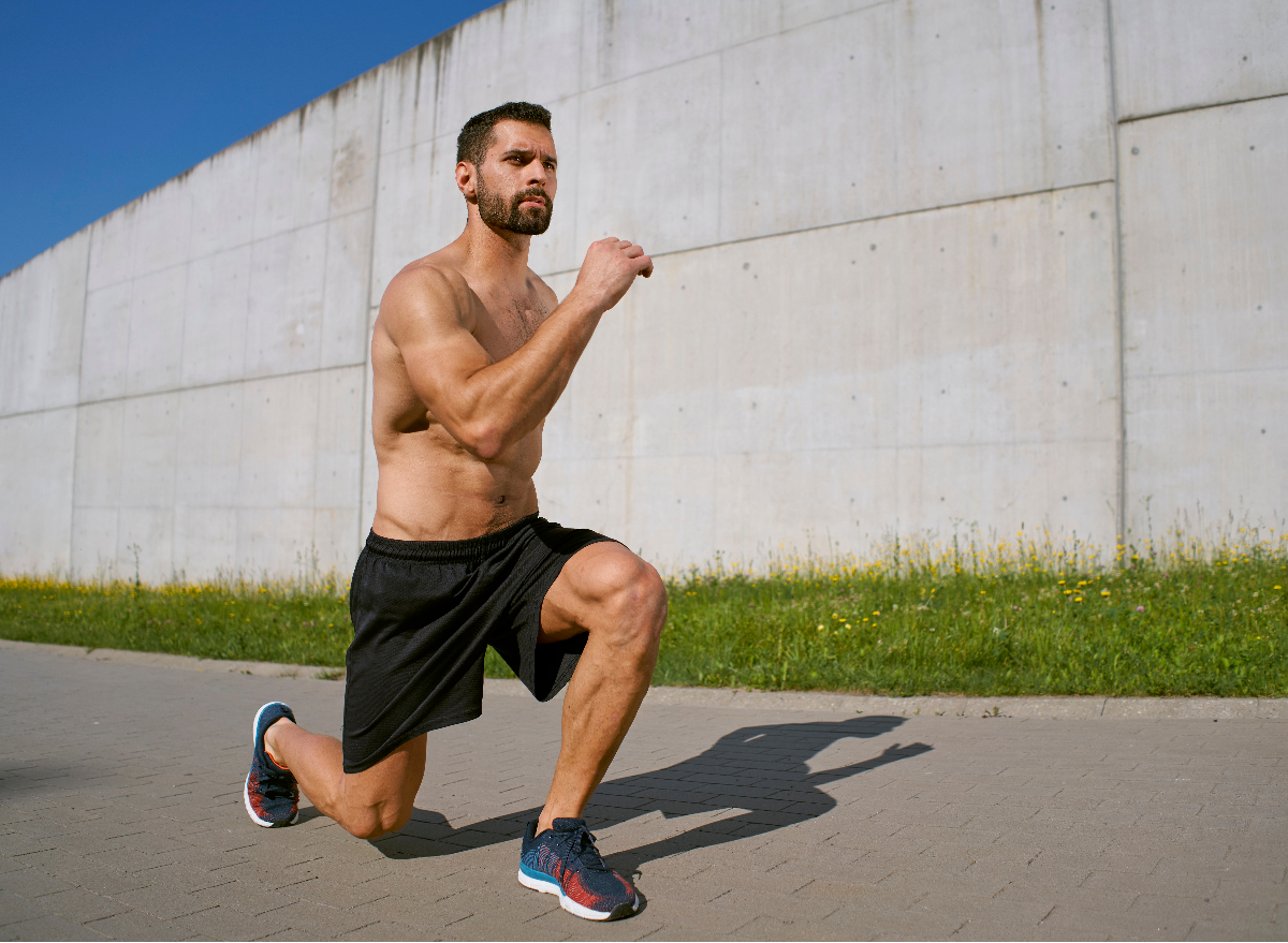 fitness man doing outdoor bodyweight exercises lunges to build muscle without heavy weights