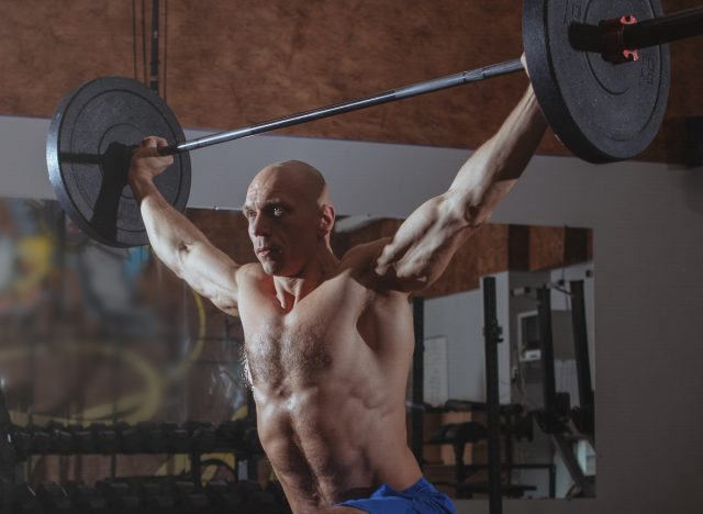 man overhead barbell press