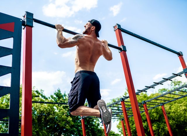 man doing pull-ups outdoors for exercises to prevent a dad bod by 40