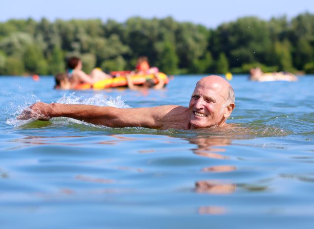 mature man swimming in lake