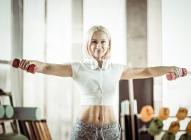 fit middle-aged woman working out with dumbbells, concept of strength exercises for women after 40