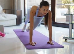 fit woman doing mountain climbers on mat, part of 10-minute indoor cardio workout