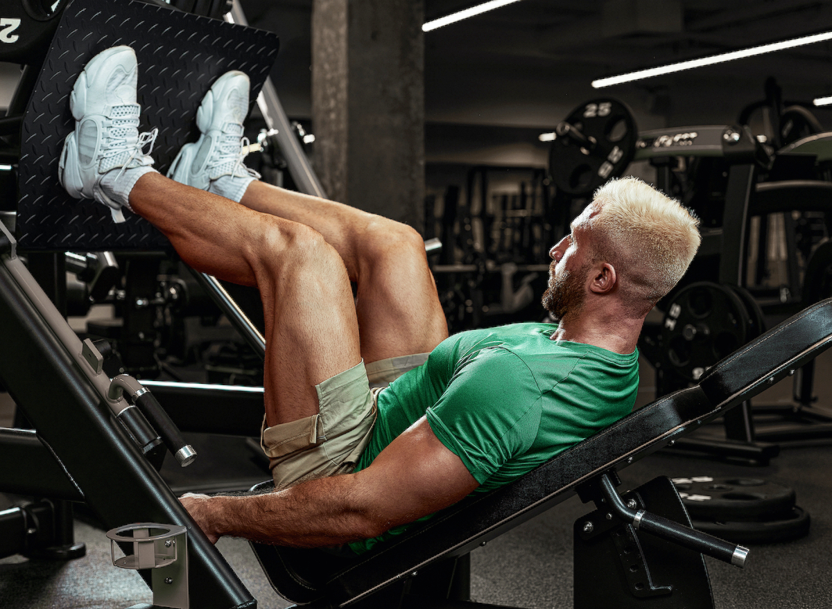muscular man at leg press machine demonstrating lower-body exercises to build up your legs