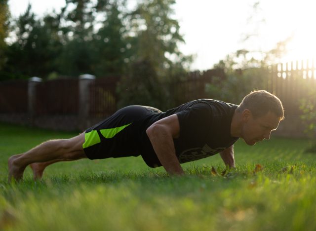 fit middle-aged man doing outdoor pushups, concept of daily exercises for men to stay fit