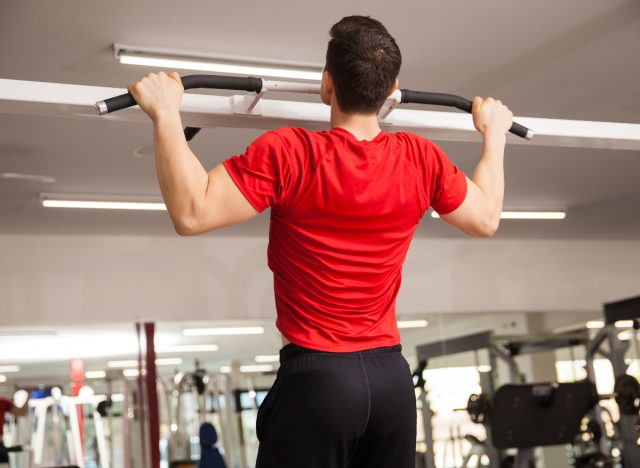 man doing pull-ups at the gym