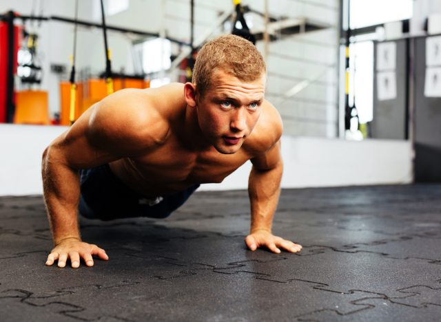 muscular man doing pushups at the gym, concept of daily exercises for men to stay fit