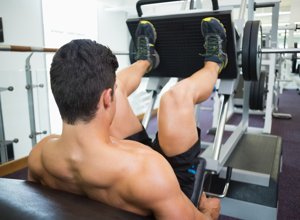 rear view of muscular man doing leg press leg workout to build muscle mass