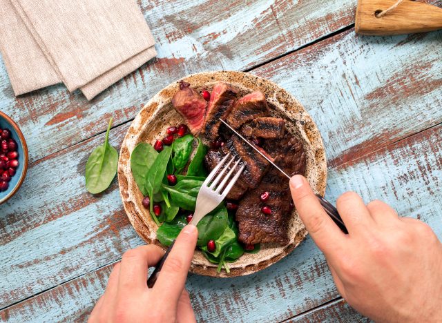 person cutting steak