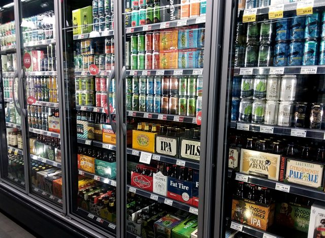 Beer and liquor fridge display inside a Whole Foods grocery store.