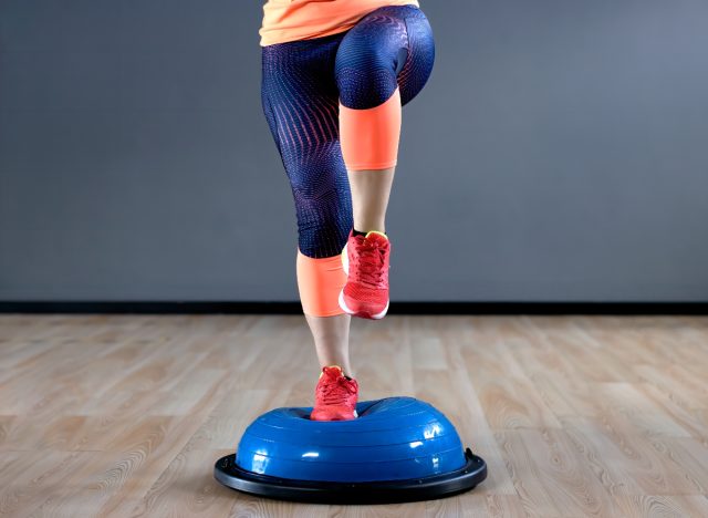 woman doing one-leg balance training exercise on BOSU ball