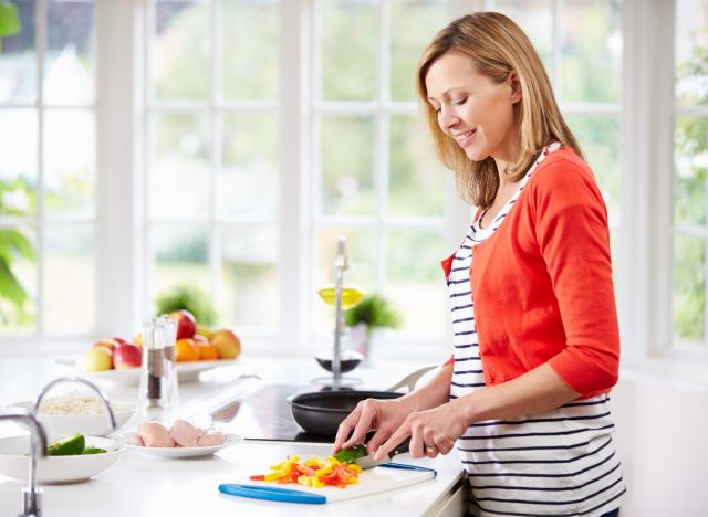 woman cooking healthy meal at home to lose weight after 40