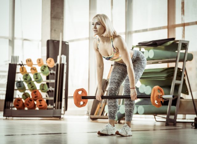 a woman is doing a deadlift exercise with a barbell