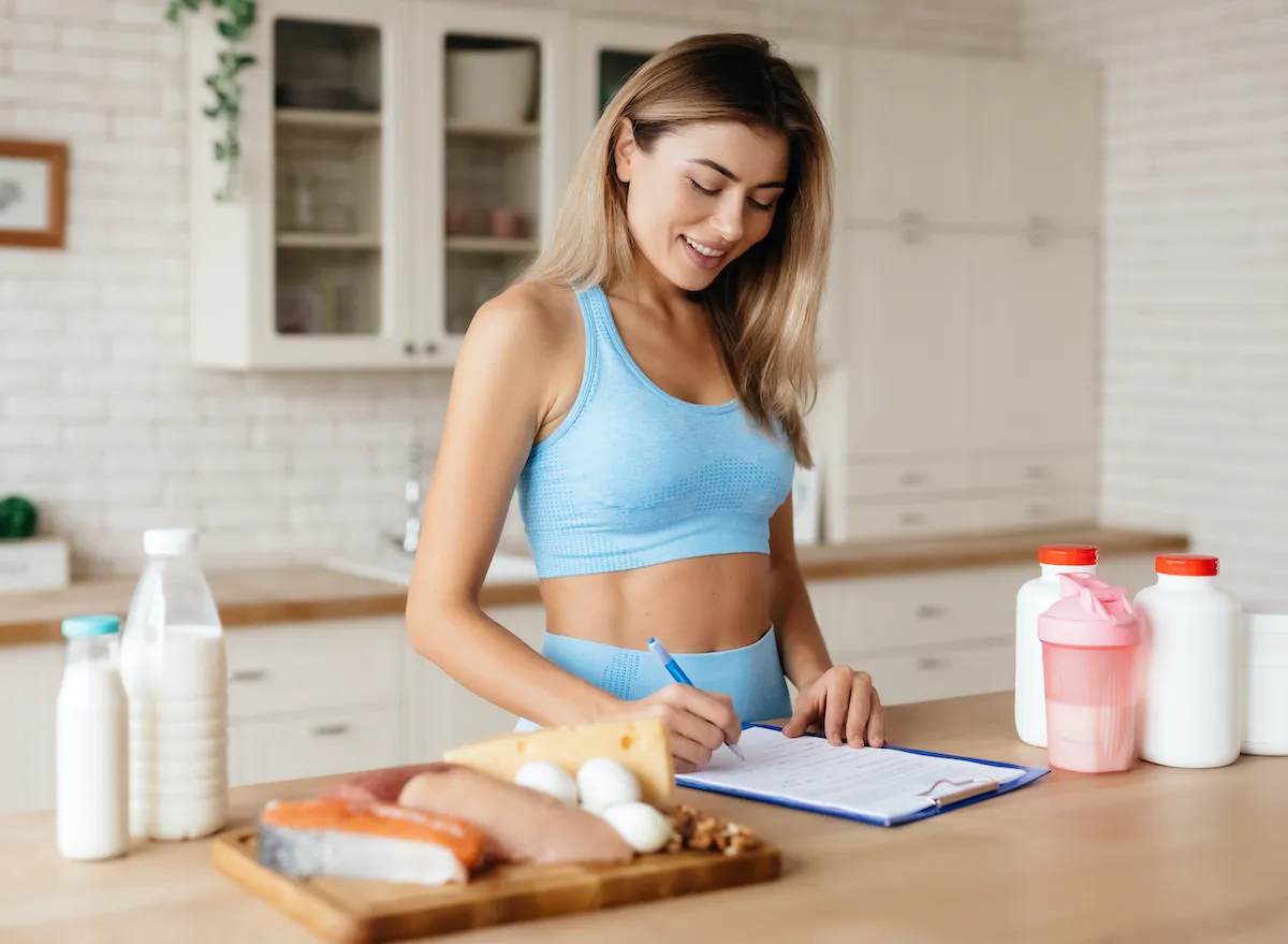 fit woman keeping track of eating habits in food diary, concept of tips to lose weight for good