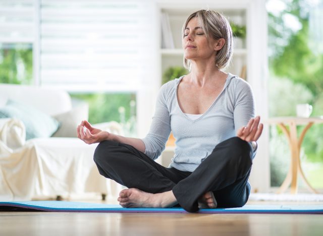 woman meditating at home, concept of how to lose weight after 40