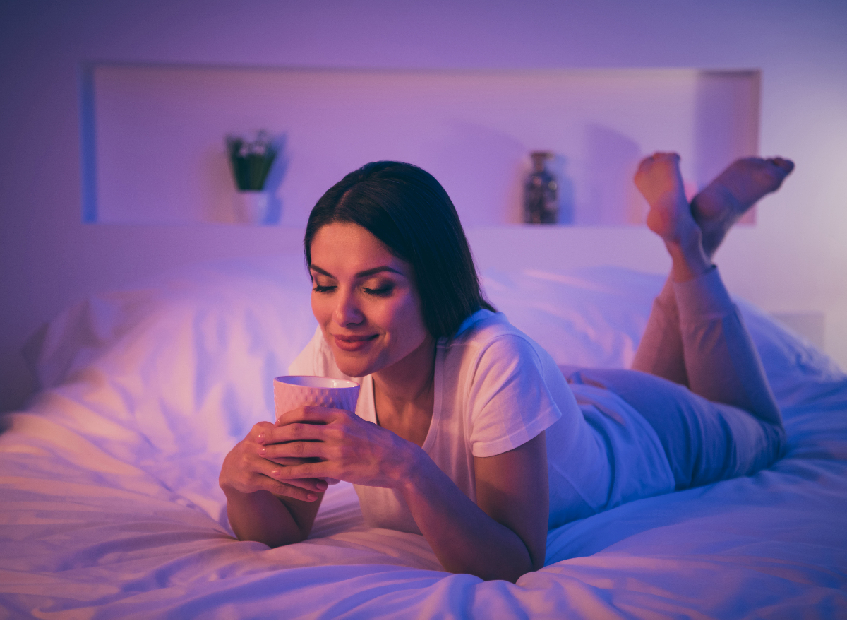 woman drinking tea on bed, nighttime, concept of habits to lose more weight