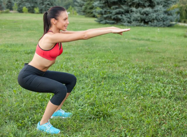 woman doing squats leg strengthening exercises in the park