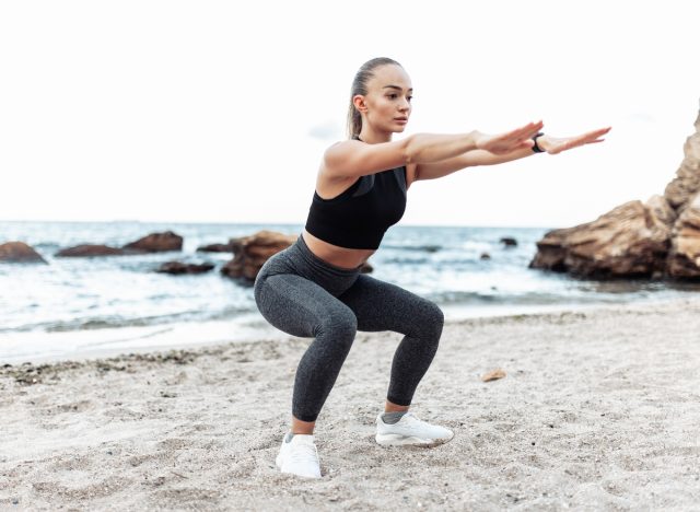 woman squatting, demonstrating beach workout exercises to help you poop