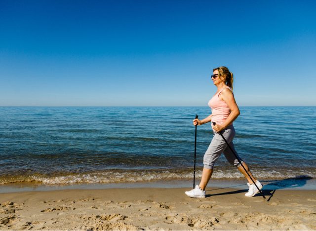 woman walking on sandy beach getting exercise