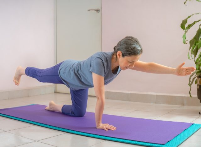 mature woman doing yoga balance training exercises, concept of tips for women to prevent muscle loss