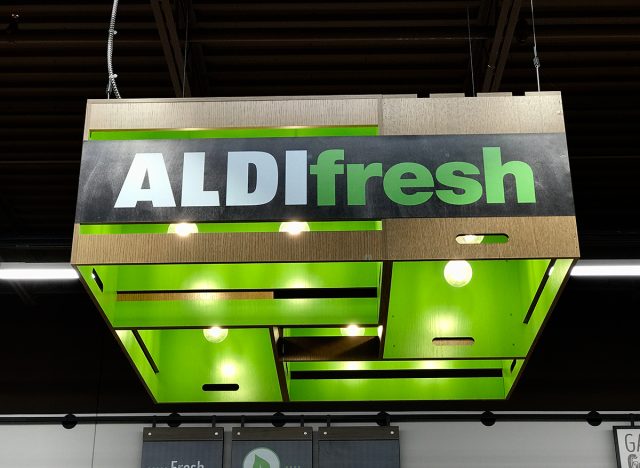 The interior ceiling of an Aldi grocery store featuring the Aldi fresh signage which is near the produce.