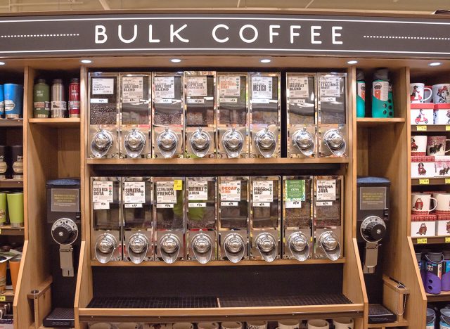  Row of variety organic raw coffee beans in vending machine at Whole Foods store.