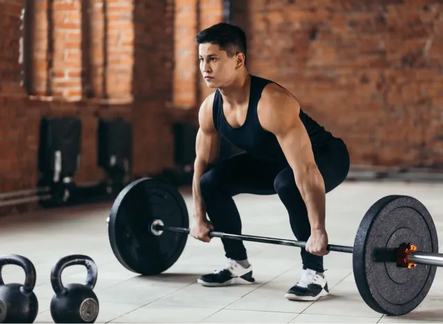 fitness man doing barbell deadlifts at the gym