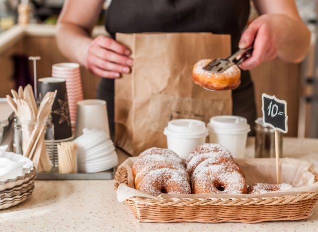 barista adding a doughnut pastry to a coffee order