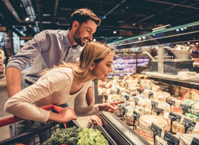 couple choosing cheese at the grocery store