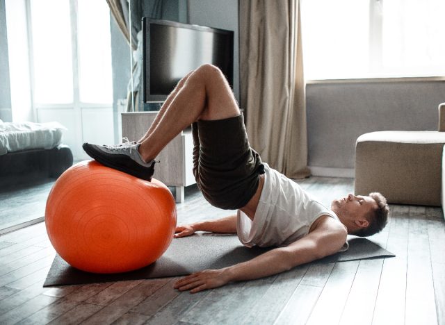 man doing exercise ball bridge