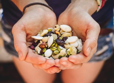 hands cupping trail mix, concept of what to eat after workout for weight loss